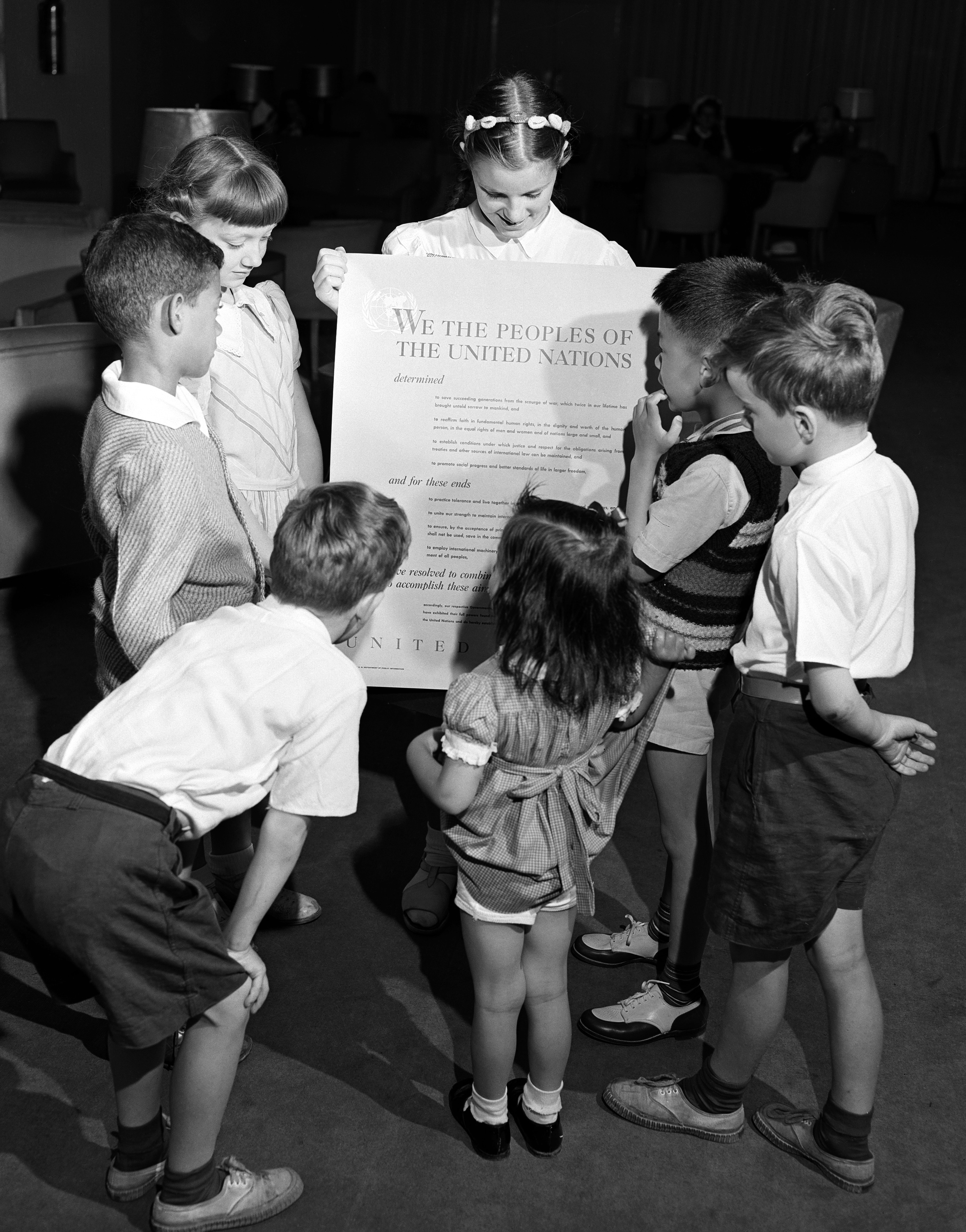 Children hold up the UN Charter
